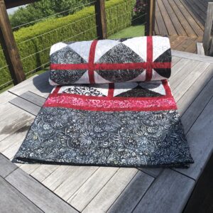Quilt for sale rolled up on tabl;e