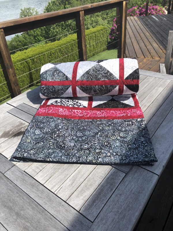 Quilt for sale rolled up on tabl;e